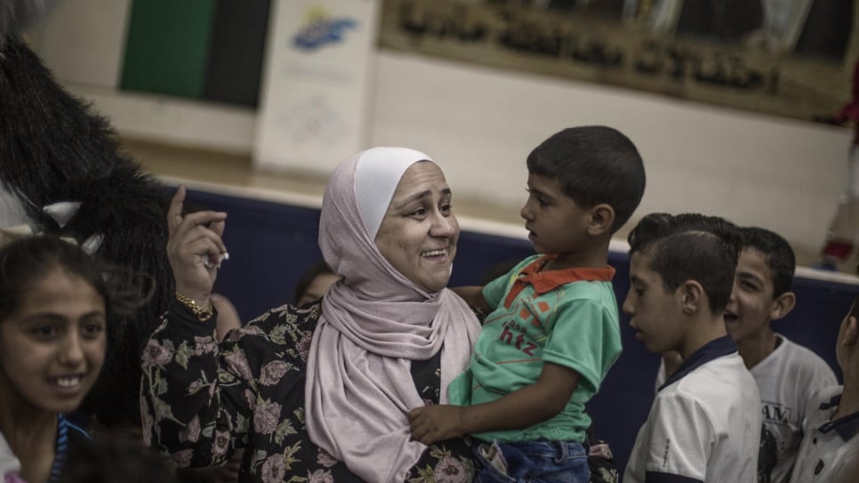 Abeer Khreisha plays with a Syrian refugee child at a community centre in Madaba, Jordan.