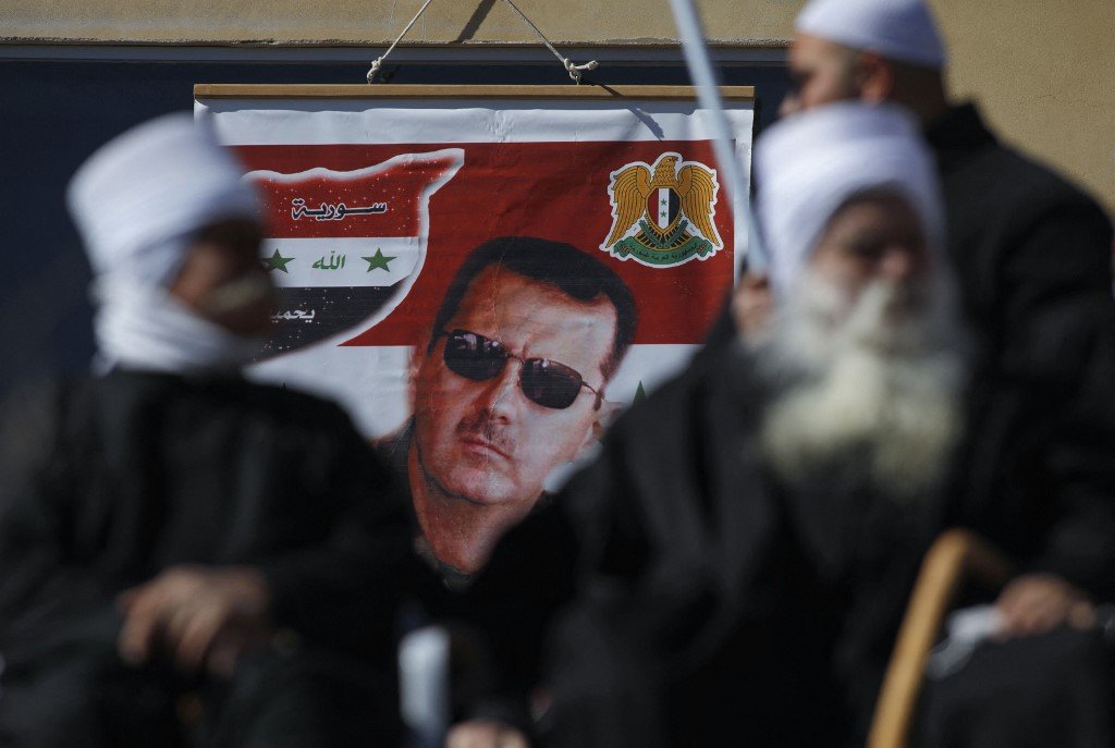 A billboard bearing a portrait of Syrian President Bashar al-Assad is pictured in the Israeli-annexed Golan Heights on 14 February 2021 (AFP)